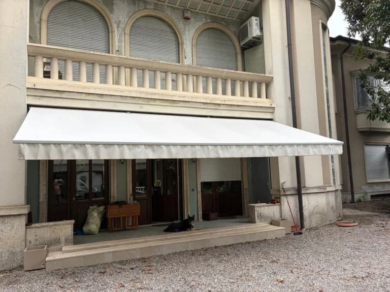 Tenda da sole a bracci su una facciata con portico