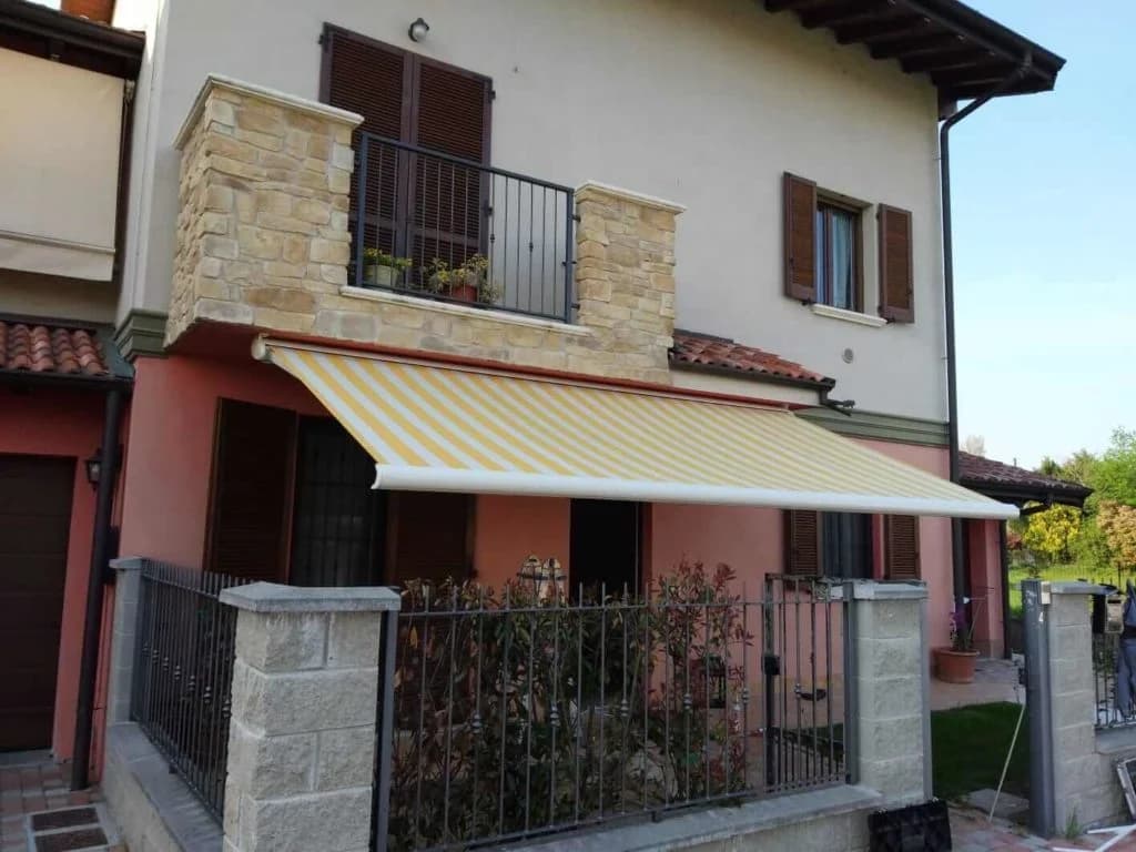 Tenda a bracci a righe su una facciata residenziale